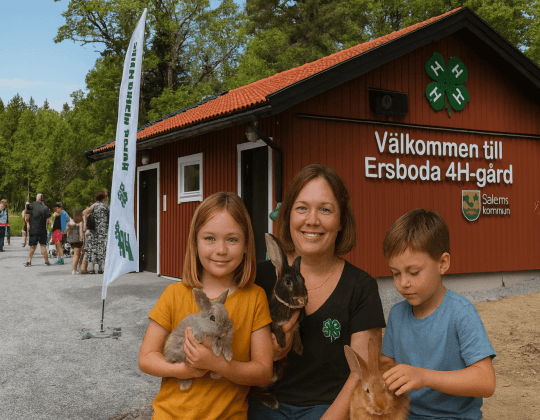 Ersboda 4H-gård med barn som håller kaniner framför den röda gårdsbyggnaden.